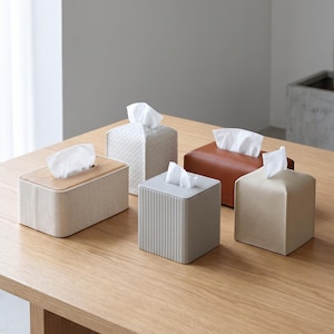 Rectangular PU leather tissue box cover with linen‑style beige texture and stitched wooden top, designed to fit standard Kleenex rectangular boxes. Features a modern, minimalist look that blends seamlessly with home décor styles from contemporary to boho. Durable magnetic closure allows easy tissue replacement, while the elegant design makes it perfect for bathroom, bedroom, living room, or office use. A stylish and functional home accessory or thoughtful gift idea.