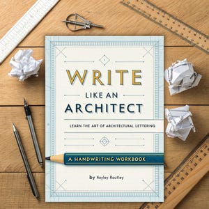 Puede incluir: Un libro azul y blanco titulado "Write Like An Architect: Learn the Art of Architectural Lettering" con el subtítulo "A Handwriting Workbook" de Hayley Routley. El libro está sobre una superficie de madera con lápices, reglas y papel arrugado.