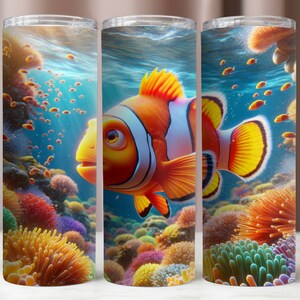 May include: A colorful tumbler with a vibrant image of a clownfish swimming among coral reefs. The fish has orange and white stripes and is surrounded by colorful coral and other fish.