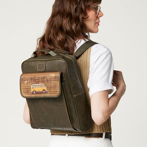 Könnte beinhalten: Olivgrüner Rucksack mit rechteckiger Form und einer Klappentasche. Die Klappe zeigt eine farbenfrohe Illustration eines gelben Vans. Der Rucksack hat verstellbare Träger und einen oberen Griff. Die Tasche ist aus strapazierfähigem Material.