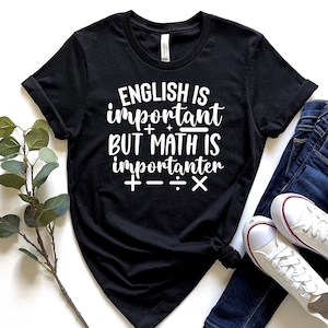 May include: Black t-shirt with white text that reads "English is important + but math is importanter + - ÷ x".