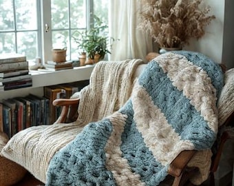 Könnte beinhalten: Eine blaue und cremefarbene, grob gestrickte Decke mit diagonalem Streifenmuster, die über einem Holzarmstuhl drapiert ist. Eine zweite cremefarbene Decke liegt auf dem Stuhl. Ein Buch liegt auf dem Stuhl.