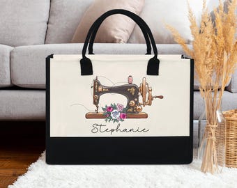 May include: A canvas tote bag with black handles and a black bottom. The bag features a vintage sewing machine illustration with a floral arrangement and the name "Stephanie" in script.