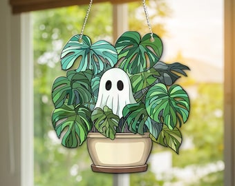 May include: A white ghost peeking out from a hanging planter filled with green monstera leaves.