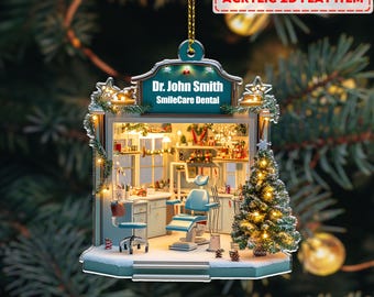 May include: A 2D acrylic Christmas decoration depicting a dental surgery. The teal sign reads "Dr. John Smith SmileCare Dental." Inside, there's a dental chair, desk, and a small Christmas tree. The ornament is decorated with fairy lights, creating a festive scene.