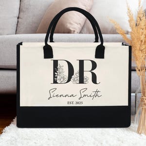 Peut inclure: Un sac fourre-tout noir et blanc avec un motif floral et les initiales "DR" au-dessus du nom "Sienna Smith" et le texte "EST. 2025".