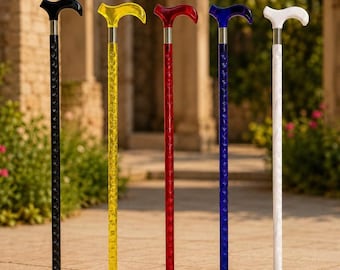May include: Five walking canes standing in a row, each featuring a curved handle and a textured, translucent shaft. The canes are available in black, yellow, red, blue, and white, all finished with a silver-toned metal collar and a black rubber tip.