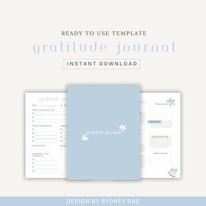 May include: A light blue gratitude journal with the words "gratitude journal" and small white flowers on the cover. The journal is open to show the inside pages with prompts for daily reflection. The words "Ready to Use Template" and "Instant Download" are also visible.
