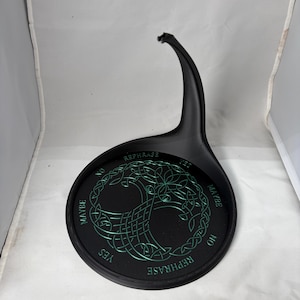 An empty black pendulum stand features a green Tree of Life symbol and divination options inside a white photographic backdrop.