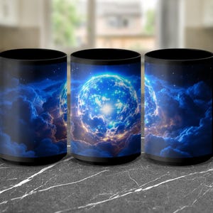 May include: Three black ceramic mugs with a celestial design. Each mug features a vibrant blue and white planet surrounded by swirling blue and orange clouds. The mugs have a glossy finish and a black handle.