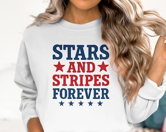 Può includere: Felpa bianca con la scritta "STARS AND STRIPES FOREVER" in blu e rosso. Il design include stelle ed è a tema patriottico.