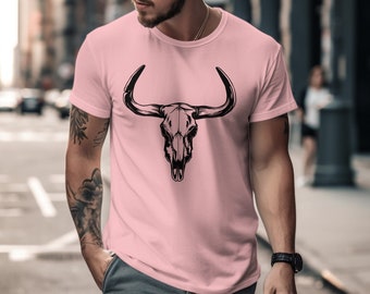 Puede incluir: Una camiseta rosa con un gráfico de cráneo de toro negro. El cráneo tiene cuernos grandes y un diseño detallado.