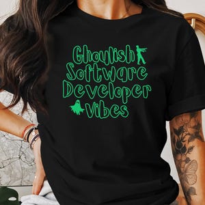 May include: Black t-shirt with green text that reads "Ghoulish Software Developer Vibes". The text is outlined in green and includes a ghost and a zombie graphic.