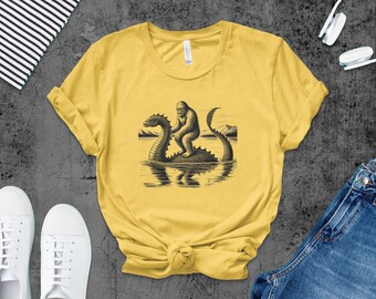 Bigfoot Riding Nessie T-Shirt: Funny Cryptozoology Graphic Tee