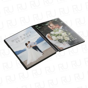 May include: An open black photo album featuring two wedding photos. The left side displays a couple kissing by a lake, with the text "Will & Kate 02.20.24." The right side shows a couple embracing, with a bouquet.