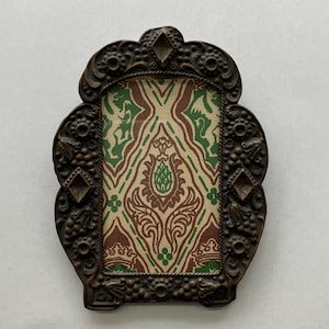 May include: A rectangular picture frame with a dark bronze-colored metal border featuring ornate floral and geometric relief carvings. The center insert displays a repeating damask-style pattern in shades of cream, forest green, and brown.