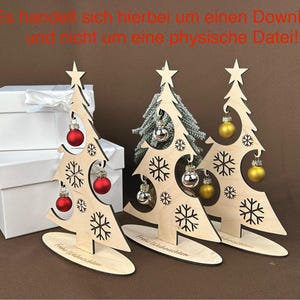 May include: Wooden Christmas tree decorations with snowflake cutouts, star toppers, and ornaments. The trees have red, silver, and gold ornaments. The base of each tree reads "Merry Christmas". White gift boxes are in the background.