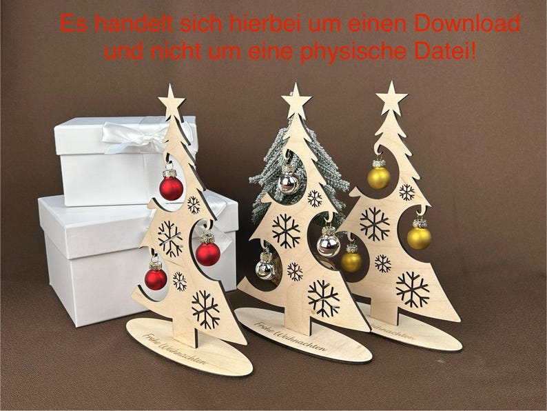 May include: Wooden Christmas tree decorations with snowflake cutouts, star toppers, and ornaments. The trees have red, silver, and gold ornaments. The base of each tree reads "Merry Christmas". White gift boxes are in the background.