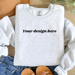 May include: A grey sweatshirt with the text "Your design here" printed on the front.