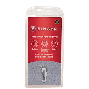 Könnte beinhalten: Ein weißer Singer Freihand-/Stopffuß für Nähmaschinen. Der Fuß ist in einer durchsichtigen Kunststoff-Blisterverpackung mit rotem Hintergrund und dem Singer-Logo verpackt. Die Verpackung enthält auch Symbole für Quilten, Dekorieren & Basteln und Nützliches.
