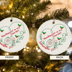May include: White ceramic Christmas ornament with the text "Needlepoint is my Therapy" in a heart-shaped design. Features a needlepoint hoop, holly, and the name "Samantha" with the year 2025.