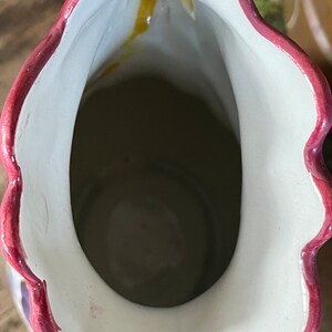 Puede incluir: El interior de una jarra de cer&aacute;mica con un esmalte blanco y un borde rosa. La jarra tiene un borde festoneado y un dise&ntilde;o floral.