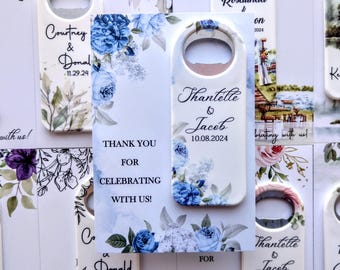 May include: White wedding favor bottle opener with blue floral design. The text reads "Thantelle & Jaceb 10.08.2024".