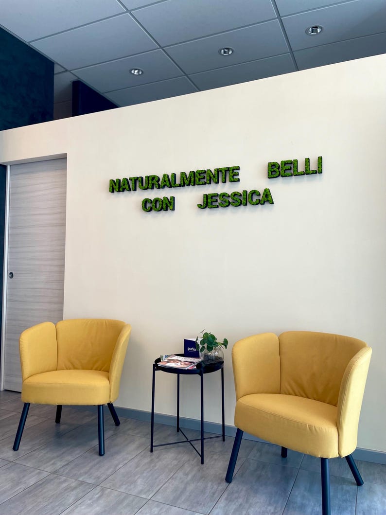 Pu&ograve; includere: Un'area d'attesa con due poltrone gialle e un tavolino nero. Sul muro la scritta "NATURALMENTE BELLI CON JESSICA" in lettere verdi. Il pavimento &egrave; piastrellato e il soffitto ha luci a incasso.