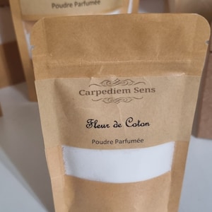以下が含まれることがあります： 白いラベルに「Carpediem Sens Fleur de Coton Poudre Parfumée」と書かれた茶色の紙袋です。