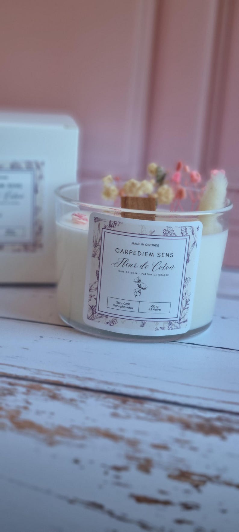 Pu&ograve; includere: Una candela bianca di cera di soia in un barattolo di vetro trasparente con uno stoppino di legno. La candela &egrave; decorata con fiori secchi e ha un'etichetta che recita "Carpediem Sens Fleur de Coton, Cire de Soja, Parfum de Grasse, Sans CMR, Sans Phthalates, 160 gr, 45 Heures".