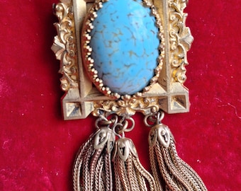 Broche de cabujón turquesa en tono dorado vintage de la década de 1930 con detalle de borlas.