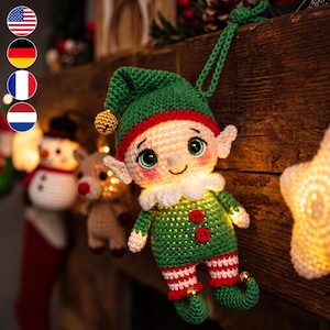 Op de afbeelding: Een gehaakt elfje als ornament met een groene muts met een gouden belletje, een witte kraag, een groene tuniek met twee rode knopen en rood-wit gestreepte benen met groene krulschoenen. Het elfje heeft grote groene ogen en een lichtgevend lijf.