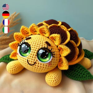 May include: A crocheted sunflower turtle with large green eyes and a brown shell. The turtle is made of yellow and brown yarn and has a smiling face.