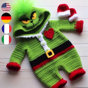 Puede incluir: Conjunto de bebé de punto verde con una cara de Grinch en la capucha, un corazón rojo, un cinturón negro y rojo y un par de guantes rojos de punto.