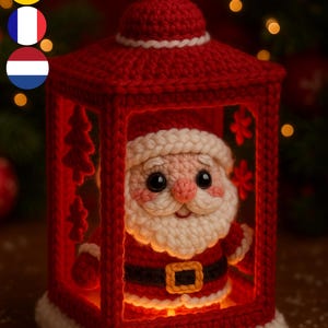 Peut inclure: Une lanterne rouge au crochet faite à la main avec une figurine du Père Noël à l'intérieur. La lanterne est de forme carrée avec une boucle en haut et une bordure blanche. Le Père Noël a une barbe blanche et un costume rouge, pour Noël.