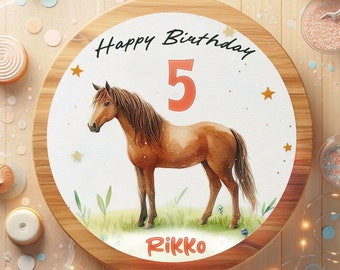 Puede incluir: Un tablero redondo de madera para pastel con fondo blanco y una ilustración de acuarela de un caballo marrón. El texto "Happy Birthday 5 Rikko" está impreso en el tablero.