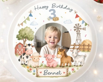 May include: A personalized birthday plate featuring a child's photo. The plate has a farm theme with illustrations of a barn, windmill, and farm animals. The text "Happy Birthday 3" and the name "Bennet" are also displayed.