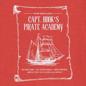 May include: Red t-shirt with a white graphic of a pirate ship and the text "CAPT. HOOK'S PIRATE ACADEMY." The graphic also includes the phrases "NO BEDTIME! NO VEGETABLES! FREE SWORDS! ABSOLUTELY NO CLOCKS ALLOWED!!!"