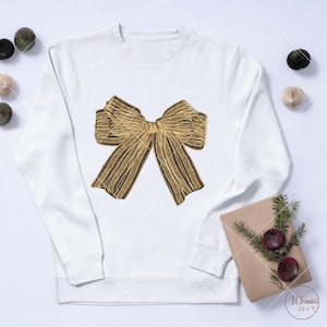 May include: A white sweatshirt featuring a gold glitter bow design.