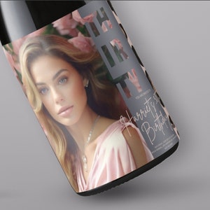 May include: A black bottle with a label featuring a woman's portrait and the word "PARTY" in a gray, cut-out design. The label also includes the text "You are invited to Harriet's 3rd Birthday". The woman is wearing a pink dress.