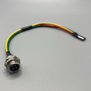 Może przedstawiać: Kabel z metalowym złączem i złączem USB-C. Kabel ma cztery przewody w kolorach żółtym, zielonym, czerwonym i pomarańczowym, pokryte czarną osłoną. Metalowe złącze ma cztery piny.