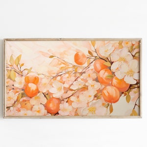 Könnte beinhalten: Ein gerahmtes Gemälde, das einen Zweig eines Baumes mit weißen Blüten und orangefarbenen Früchten zeigt. Der Hintergrund ist in einem zarten Pfirsichton gehalten.