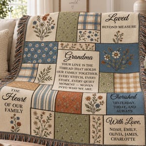 May include: A woven throw blanket featuring a patchwork design of floral, plaid, and striped patterns in muted tones. The blanket includes text such as Grandma, Loved Beyond Measure, The Heart of Our Family, and names including Noah, Emily, Olivia, James, and Charlotte.