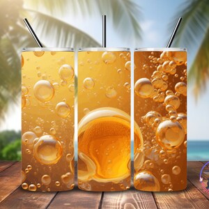 Puede incluir: Tres vasos de acero inoxidable con un diseño de burbujas naranjas y amarillas. Los vasos están sobre una superficie de madera.