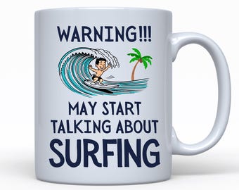 Könnte beinhalten: Weiße Keramiktasse mit einer blauen und weißen Cartoon-Illustration eines Surfers, der auf einer Welle reitet. Der Text "WARNING!!! MAY START TALKING ABOUT SURFING" ist in Blau auf die Tasse gedruckt.