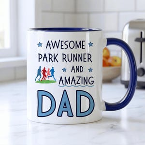 May include: White ceramic mug with a blue rim and handle. The mug features the text "AWESOME PARK RUNNER AND AMAZING DAD" in blue, with a graphic of runners. A great gift for Father's Day.