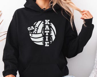 May include: Black hoodie with a white volleyball graphic and the name "KATIE" spelled out vertically on the volleyball.