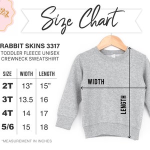 May include: Size chart for a toddler fleece unisex crewneck sweatshirt. The chart shows sizes 2T, 3T, 4T, and 5/6 with corresponding width and length measurements in inches.