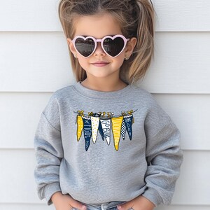 May include: A gray sweatshirt with a graphic of a string of pennants that say "Fight", "Go Blue", "Come On", and "Go Dawg".