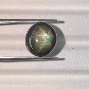 Złoty czarny szafir gwiaździsty kaboszon – asteryzm 6 promieni, podgrzewany kamień szlachetny z Tajlandii